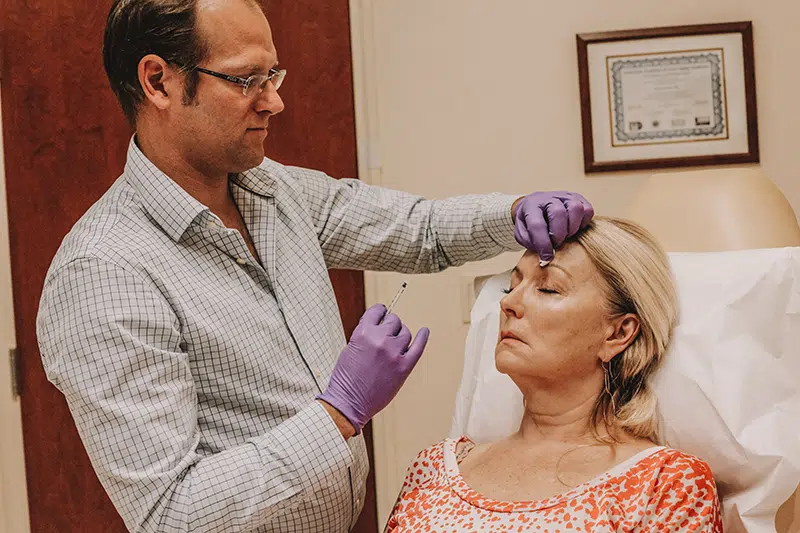 Middle-aged woman receiving dermal fillers and neuromodulators